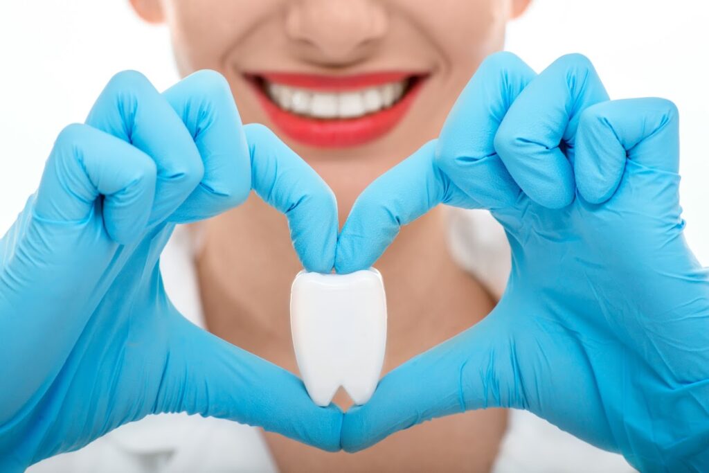 A woman holding a large tooth model 