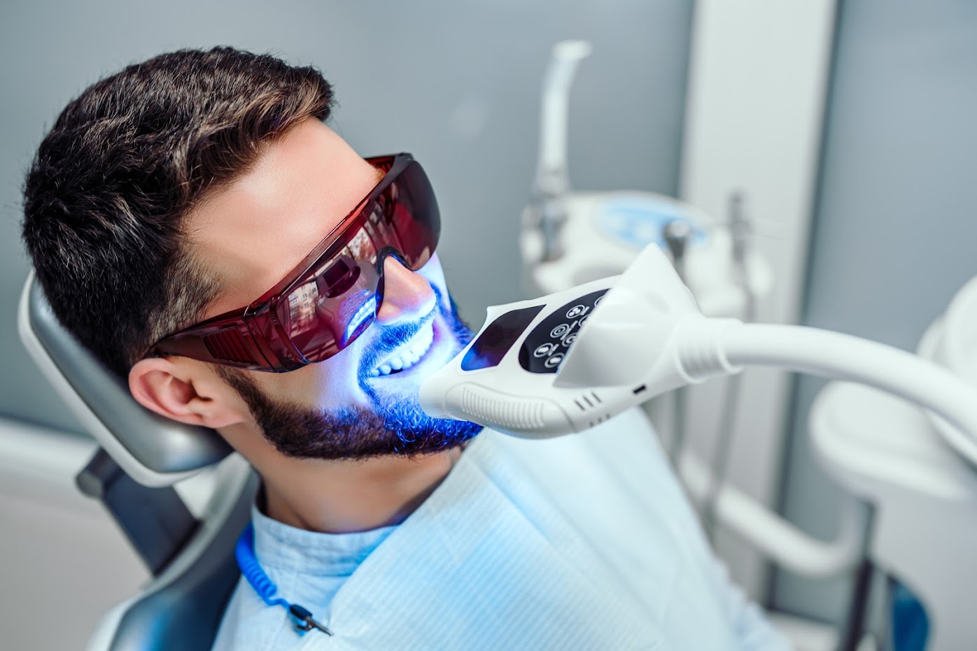 Man undergoing teeth whitening at a dentist's office